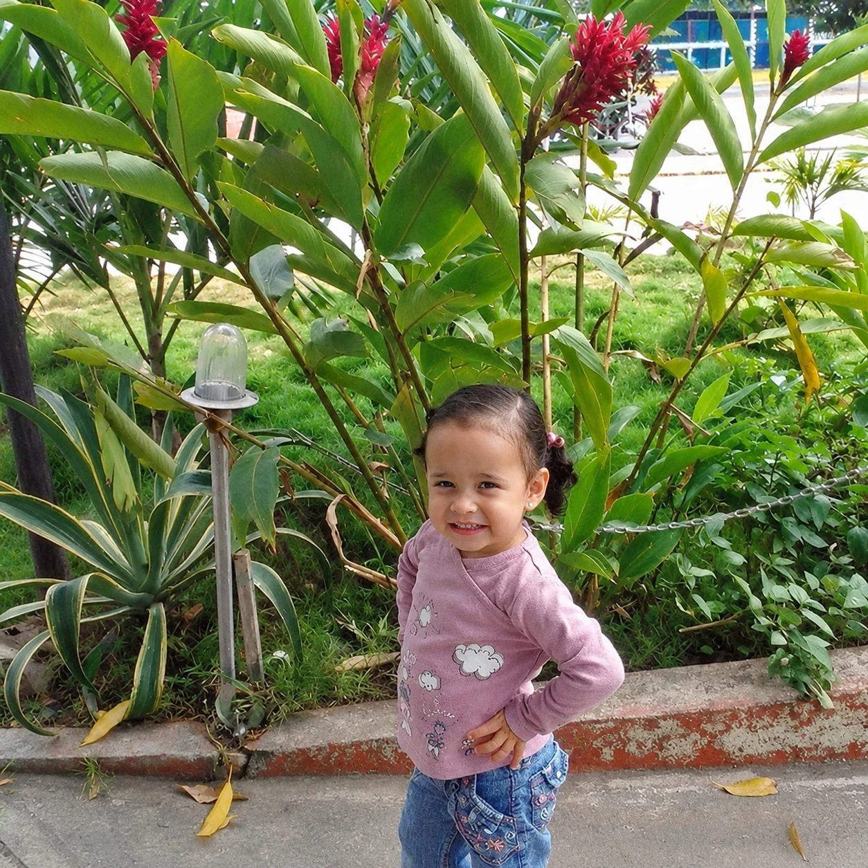 Valery de niña posando en un jardín