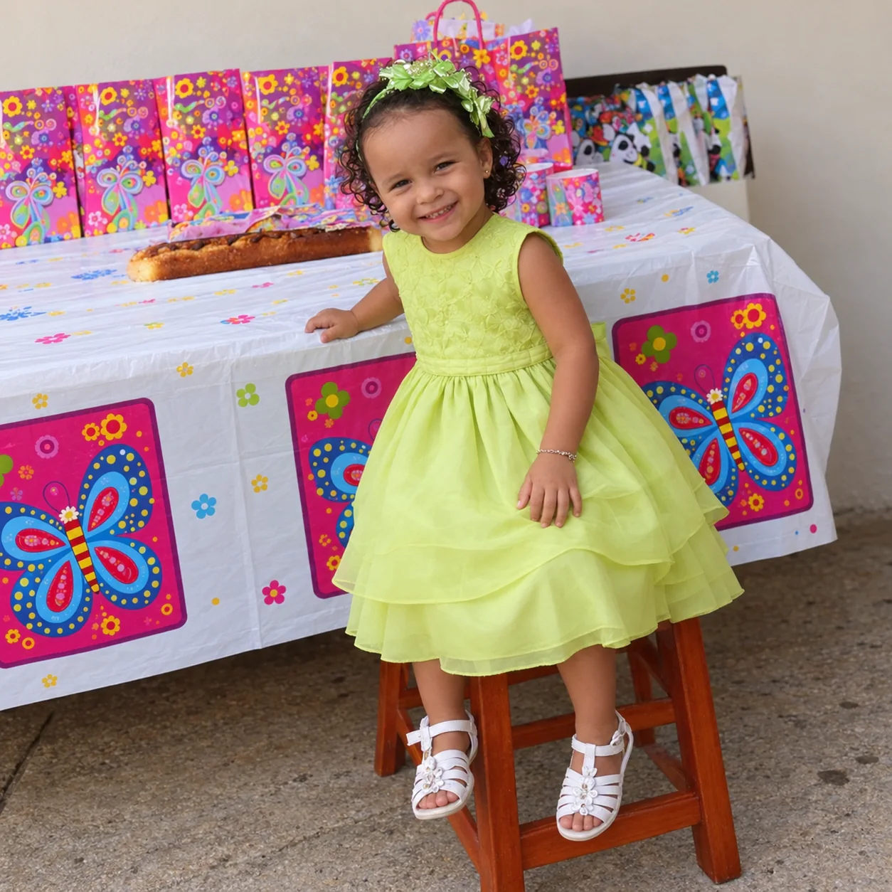 Valery de niña con vestido verde en una fiesta de mariposas