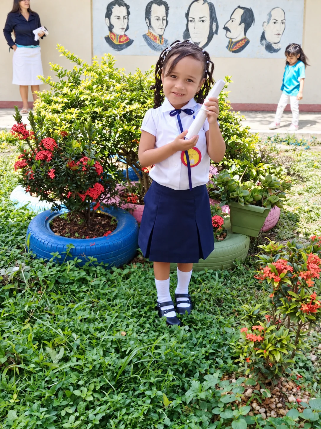 Valery de niña con uniforme escolar y su diploma